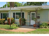 Charming front porch with decorative metal supports and landscaped garden, giving a welcoming curb appeal at 791 66Th S Ave, St Petersburg, FL 33705