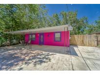 Eye-catching single story home with pink exterior, purple trim, and covered patio at 8108 E 19Th Ave, Tampa, FL 33619