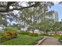 Beautifully landscaped exterior with lush green hedges, mature trees, and walkways in a well-maintained community at 1 Beach Se Dr # 811, St Petersburg, FL 33701