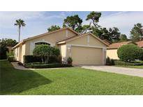 Charming single-story home with a well-manicured lawn and an attached two-car garage at 11323 Highlander Ct, Spring Hill, FL 34609
