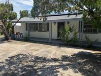 Charming single-story home featuring an inviting front porch and mature landscaping at 11423 77Th Ave, Seminole, FL 33772