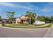 Charming corner lot home featuring manicured landscaping, mature trees, and a white picket fence at 12337 Rose Haven Blvd, New Port Richey, FL 34654