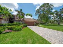 Charming home with lush landscaping, paver driveway, and a welcoming facade at 13851 Lake Point Dr, Clearwater, FL 33762