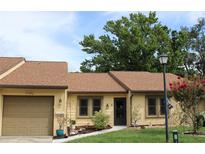 Charming home featuring a well-maintained front yard, attached garage, and cozy entryway at 2101 Sunset Point Rd # 2304, Clearwater, FL 33765
