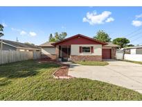 Charming single story home features a red roof, brick accents, and mature landscaping at 2233 Curlew Rd, Dunedin, FL 34698