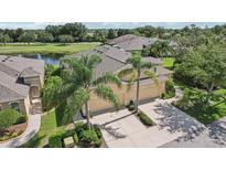 Inviting home with a two-car garage, mature palms, and a scenic pond view in a well-maintained neighborhood at 2427 Nottingham Greens Dr, Sun City Center, FL 33573