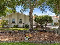 Charming home featuring well-maintained landscaping, mature trees, and a decorative garden gnome accent at 2436 Nuremberg Blvd, Punta Gorda, FL 33983