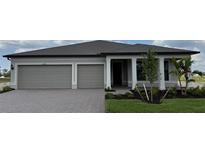 Beautiful single-story home with a two-car garage, neutral paint, and professional landscaping at 2589 Winding Creek Trl, North Port, FL 34289