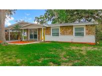 Charming single-story home with a stone facade and a well-manicured lawn at 307 Fern Cliff Ave, Temple Terrace, FL 33617