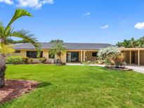 Charming single-story home with lush lawn, mature palms, and a convenient covered carport at 3944 49Th S Ave, St Petersburg, FL 33711