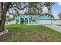 Charming turquoise home with a well-manicured lawn and a two-car garage at 5283 Bevens Ave, Spring Hill, FL 34608