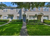 Inviting townhouse with blue shutters, well-manicured lawn, and a charming covered entrance at 5717 Fishhawk Ridge Dr, Lithia, FL 33547