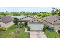 Charming single-story home featuring a well-manicured lawn and an attached two-car garage with lake view at 636 Chatham Walk Dr, Ruskin, FL 33570