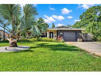 Charming single-story home featuring a well-manicured lawn and tropical landscaping in a sunny, bright setting at 6844 34Th N Ave, St Petersburg, FL 33710