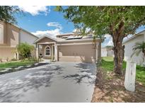 Charming single-Gathering home featuring a two-car garage, well-manicured lawn, and solar panels for energy efficiency at 11130 Summer Star Dr, Riverview, FL 33579
