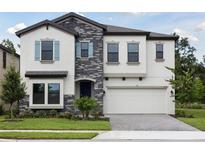 Beautiful two-story home with a stone facade and well-manicured lawn offers great curb appeal at 12758 Oak Hill Way, Parrish, FL 34219