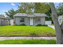 Inviting front yard with lush green grass and mature trees at 1743 Fulton Ave, Clearwater, FL 33755