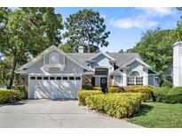 Charming single-Gathering home with a manicured lawn, beautiful landscaping, and an attached two-car garage at 2182 Trevor Rd, Palm Harbor, FL 34683