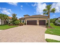 Beautiful single-story home with a paver driveway, lush landscaping and a two-car garage at 3214 Forsythia Dr, Odessa, FL 33556