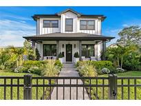 Charming two-story home features a well-manicured front yard with lush landscaping and a black iron fence at 468 44Th N Ave, St Petersburg, FL 33703