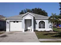 Charming single-story home featuring a well-maintained front yard, gray paint, and attached one-car garage at 1006 Harvest Moon Dr, Seffner, FL 33584
