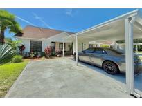 Charming single-story home with a covered carport and meticulously landscaped front yard at 10636 Millriver Dr, New Port Richey, FL 34654