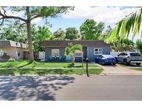 Charming single-story home featuring a well-manicured lawn, a blue front door, and ample parking on a sunny day at 12316 Eldon Dr, Largo, FL 33774