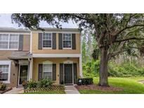 Inviting two-story townhome featuring a well-maintained lawn and black shutters on the windows at 1247 Kennewick Ct, Wesley Chapel, FL 33543