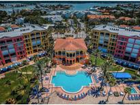 Stunning aerial view of condos with a large pool, palm trees, and beautiful landscaping at 16600 Gulf Blvd # 437, North Redington Beach, FL 33708