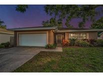 Charming single-story home featuring an attached garage, well-maintained lawn, and beautiful landscaping at 2010 Groveland Rd, Palm Harbor, FL 34683