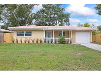 Charming single story home featuring a light color scheme, a well maintained lawn, and an attached garage at 2333 Indigo Dr, Clearwater, FL 33763