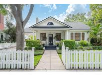 Charming two-story home featuring a classic white picket fence, lush landscaping, and a welcoming front porch at 2412 W Prospect Rd, Tampa, FL 33629