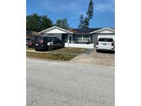 Charming single-story home with gray exterior, solar panels, and a well-maintained front yard and driveways at 4219 Gray Squirrel Ln, New Port Richey, FL 34653