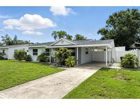 Charming single-story home with a well-manicured lawn, carport, and inviting curb appeal at 6212 S Adelia Ave, Tampa, FL 33616