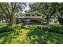 Charming two-story home featuring a brick facade and lush landscaping surrounding the property at 6505 Cedar Ne St, St Petersburg, FL 33702