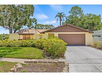 Charming single-story home featuring a two-car garage and lush landscaping for added curb appeal at 8405 Woodbridge Blvd, Tampa, FL 33615