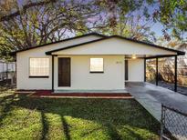 Charming single-story home featuring a carport, fresh exterior paint, and well-manicured lawn at 9312 N Tampa St, Tampa, FL 33612