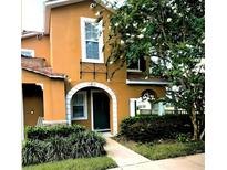 Charming two-story home featuring an arched entryway, well-manicured landscaping, and warm exterior tones at 10819 Lake Saint Charles Blvd, Riverview, FL 33578
