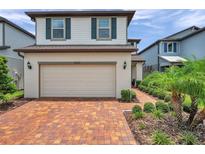 Charming two-story home features a brick driveway, a two-car garage, and well-manicured landscaping at 18144 Frame Bnd, Land O Lakes, FL 34638