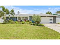 Inviting single-story home boasts lush landscaping, mature trees, and a modern exterior design with a charming front yard at 2581 61St S Ave, St Petersburg, FL 33712