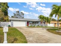 Charming single-story home with a well-manicured lawn, long driveway, and a two-car garage at 3173 Fountainhead Dr, Largo, FL 33770