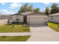 Charming single-story home features a two-car garage, well-maintained lawn, and lovely landscaping at 39024 Harlow Rose Dr, Zephyrhills, FL 33540