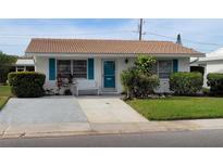 Charming single-story home with well-manicured lawn, tidy landscaping and blue shutters at 4470 Mainlands W Blvd, Pinellas Park, FL 33782