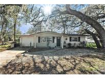 Charming single-story home with mature trees, landscaped yard, and a quaint covered front porch at 4928 Petunia Ct, New Port Richey, FL 34652