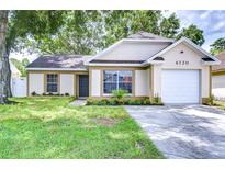 Charming single-Gathering home featuring an attached garage and well-maintained landscaping at 6720 Gilda Dr, Tampa, FL 33625