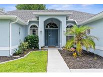 Charming home featuring a beautiful arched entryway, well-maintained landscaping, and a welcoming front door at 10457 Cranston St, Spring Hill, FL 34608