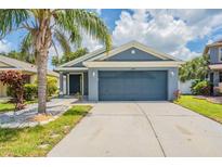 Charming one-story home with a well-manicured lawn and a two-car garage at 11448 Bay Gardens Loop, Riverview, FL 33569