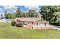 Charming single-story home featuring a well-manicured lawn and inviting landscaping with a tan color scheme at 13167 Roseanna Dr, Spring Hill, FL 34609