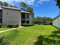 Well-maintained condo with lush green lawn and mature landscaping at 140 Nina Way, Oldsmar, FL 34677