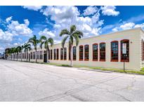 Attractive commercial building with large windows, palm trees, and a vibrant blue sky at 2001 E 2Nd Ave # 12, Tampa, FL 33605